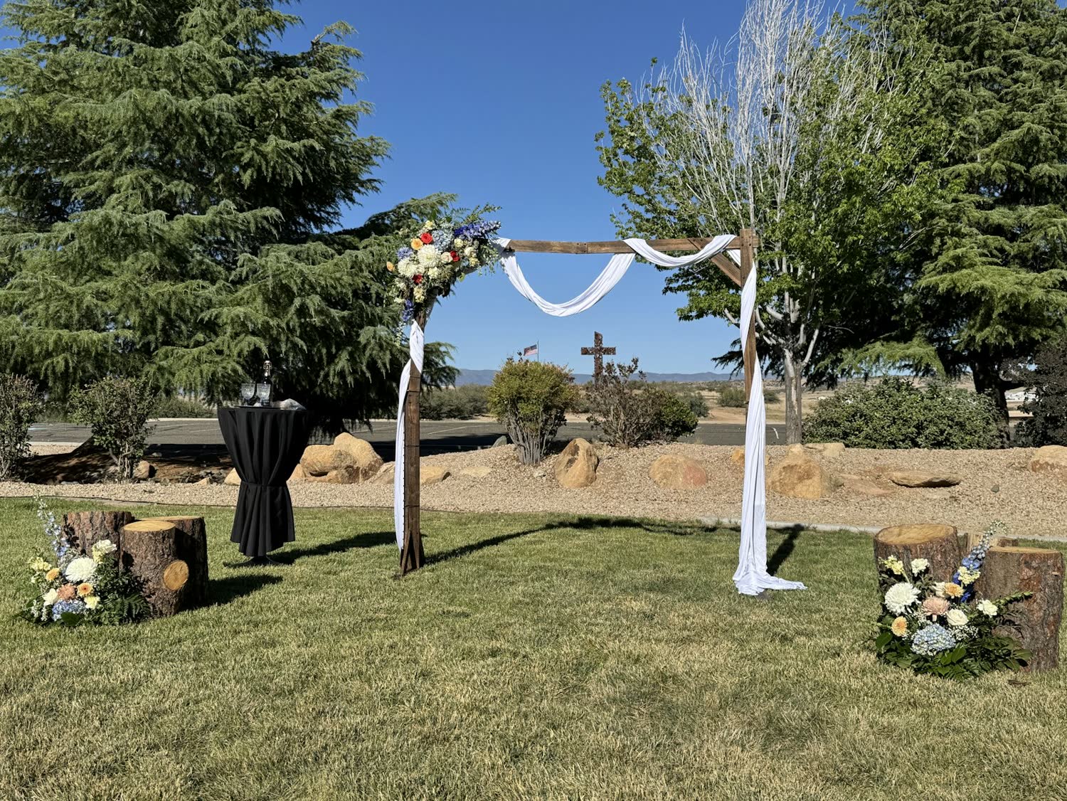 A ceremony arch dressed with white fabric on the lawn